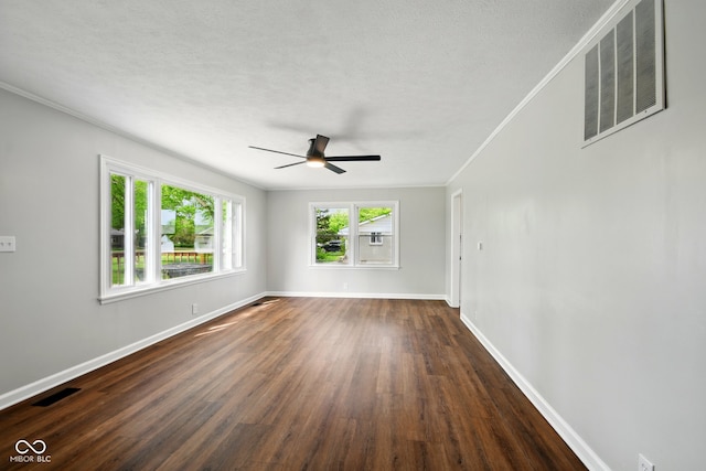 empty room featuring ornamental molding, ceiling fan, dark wood-style flooring, baseboards, and a textured ceiling