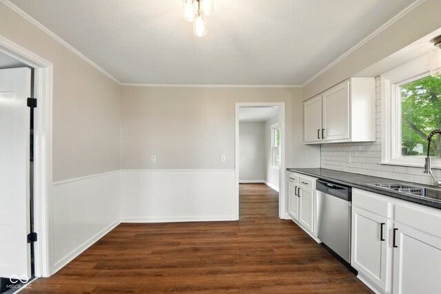 kitchen featuring dishwasher, dark countertops, a sink, dark wood finished floors, and plenty of natural light