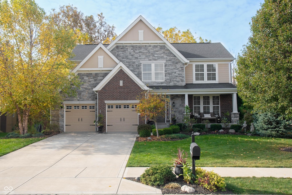 665 Featherstone Dr, Westfield, IN 46074 - craftsman house with stone siding, a front lawn, driveway, and a porch