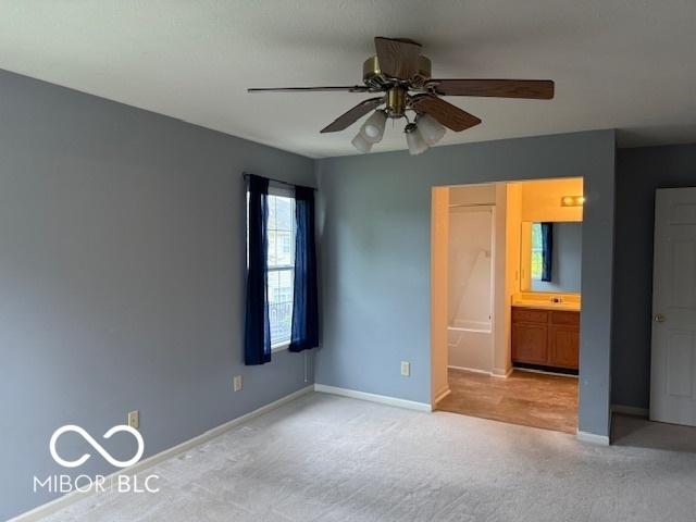 8002 Windham Lake Way Unit 33, Indianapolis, IN 46214 - unfurnished bedroom featuring carpet flooring, baseboards, connected bathroom, and ceiling fan