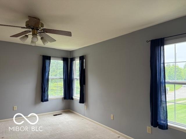 8002 Windham Lake Way Unit 33, Indianapolis, IN 46214 - empty room featuring healthy amount of natural light, baseboards, carpet, and ceiling fan