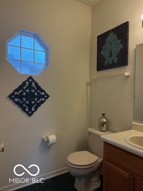 8002 Windham Lake Way Unit 33, Indianapolis, IN 46214 - half bath featuring toilet, vanity, and tile patterned flooring