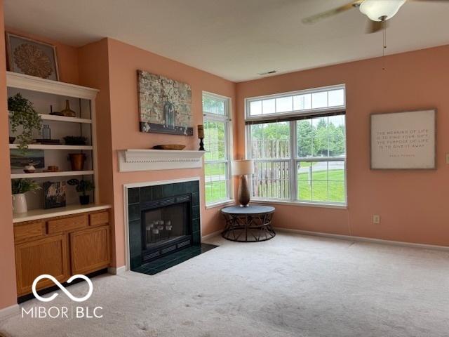 8002 Windham Lake Way Unit 33, Indianapolis, IN 46214 - carpeted living room with a tiled fireplace, a ceiling fan, and baseboards