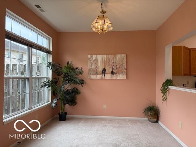 8002 Windham Lake Way Unit 33, Indianapolis, IN 46214 - spare room with a chandelier, carpet floors, and baseboards
