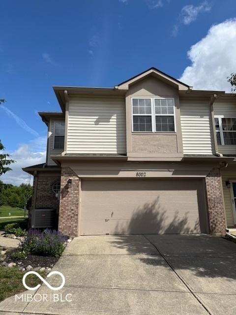 8002 Windham Lake Way Unit 33, Indianapolis, IN 46214 - view of front of house with an attached garage, brick siding, cooling unit, and driveway