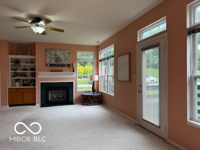 8002 Windham Lake Way Unit 33, Indianapolis, IN 46214 - living area featuring carpet flooring, healthy amount of natural light, ceiling fan, and a tiled fireplace