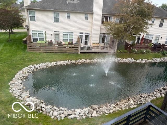 8002 Windham Lake Way Unit 33, Indianapolis, IN 46214 - rear view of property with a chimney, a yard, a deck with water view, and a shingled roof