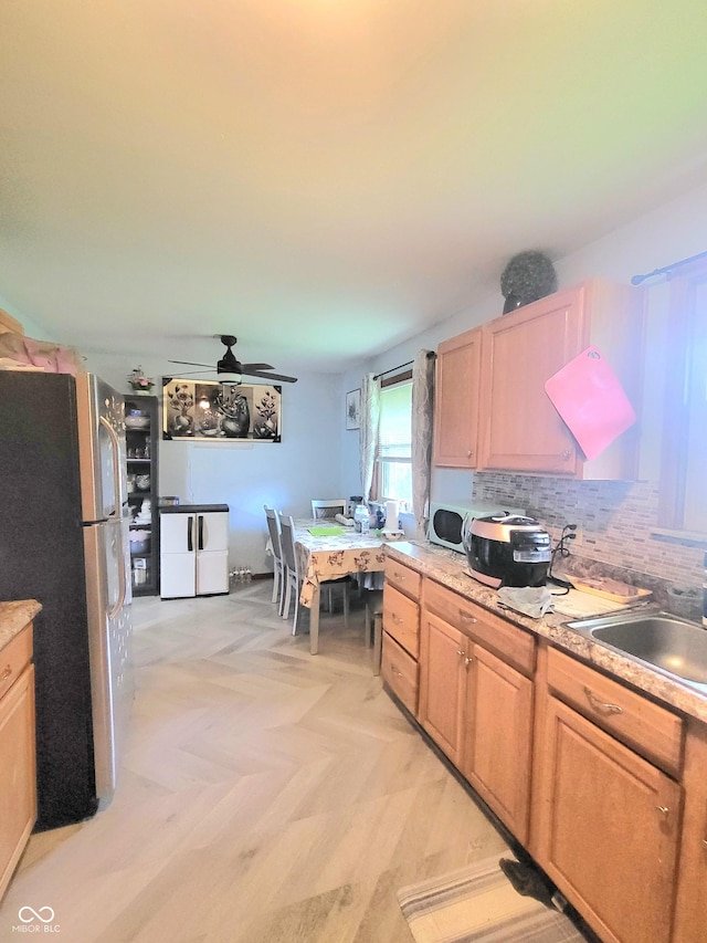 7109 Chandler Dr, Indianapolis, IN 46217 - kitchen with freestanding refrigerator, a ceiling fan, a sink, backsplash, and light countertops