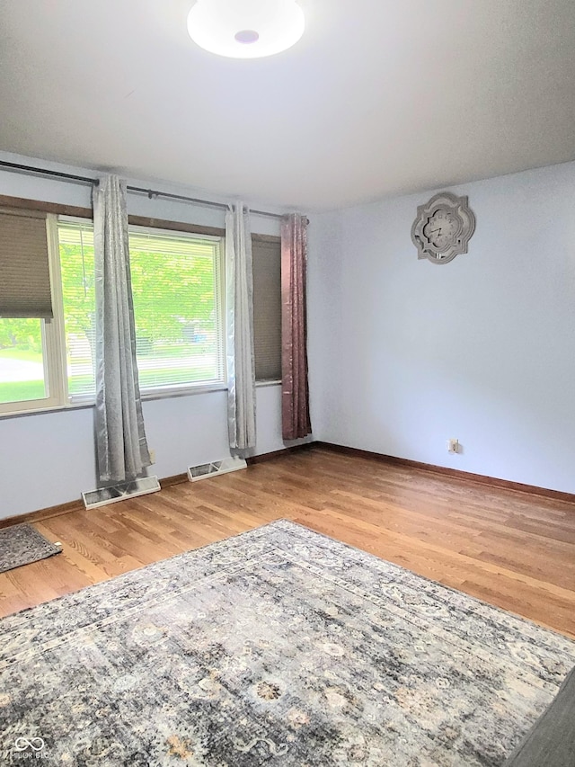 7109 Chandler Dr, Indianapolis, IN 46217 - empty room with baseboards, visible vents, and wood finished floors