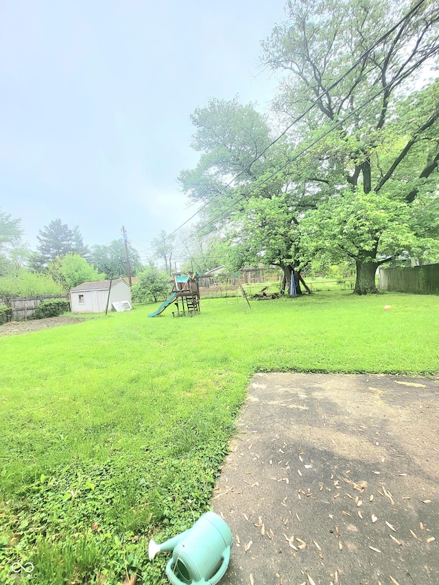7109 Chandler Dr, Indianapolis, IN 46217 - view of yard featuring a playground, an outdoor structure, fence, and a shed