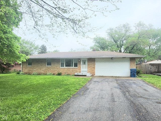 7109 Chandler Dr, Indianapolis, IN 46217 - single story home featuring an attached garage, fence, aphalt driveway, a front yard, and brick siding