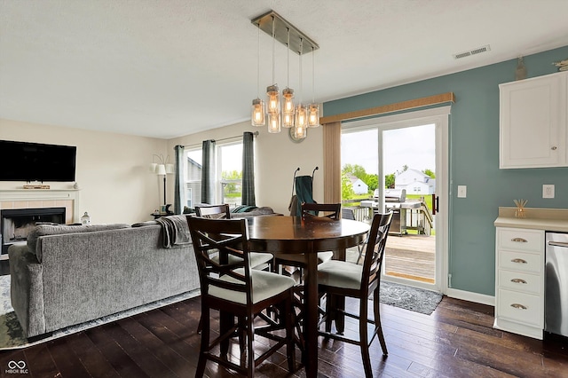 6624 Lakestone Ct, Indianapolis, IN 46237 - dining space featuring dark wood-style flooring, a tile fireplace, a chandelier, and baseboards