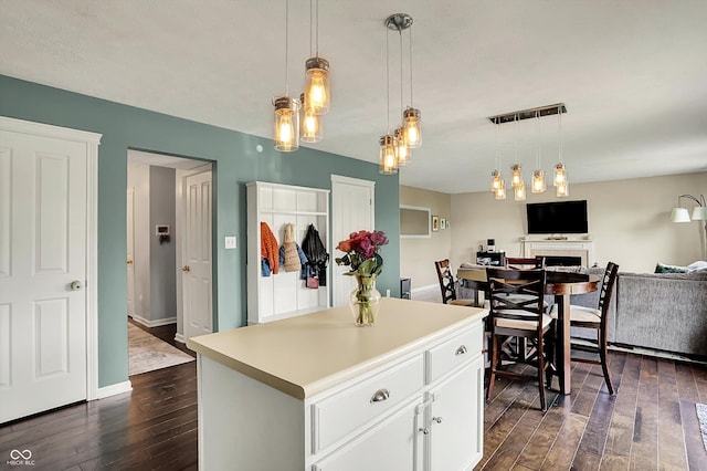 6624 Lakestone Ct, Indianapolis, IN 46237 - kitchen featuring dark wood-style flooring, white cabinets, pendant lighting, a fireplace, and open floor plan