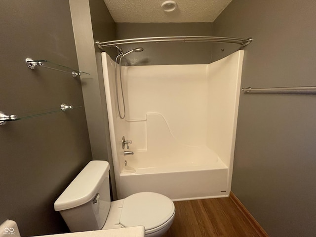 8234 Crosser Dr, Indianapolis, IN 46237 - bathroom featuring toilet, wood finished floors, bathtub / shower combination, a textured ceiling, and baseboards