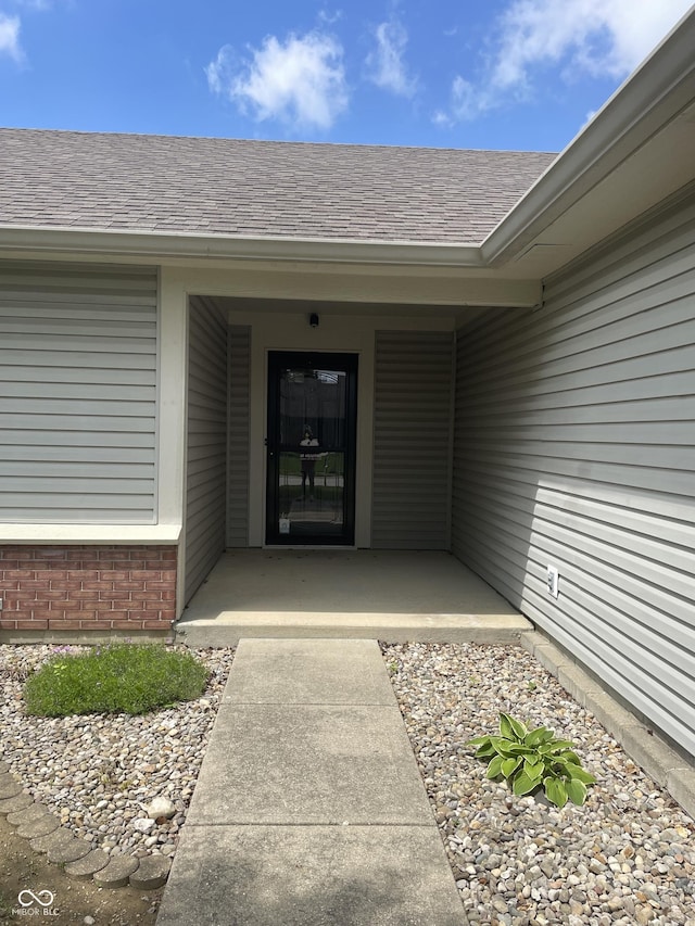 8234 Crosser Dr, Indianapolis, IN 46237 - property entrance with a shingled roof, covered porch, and brick siding