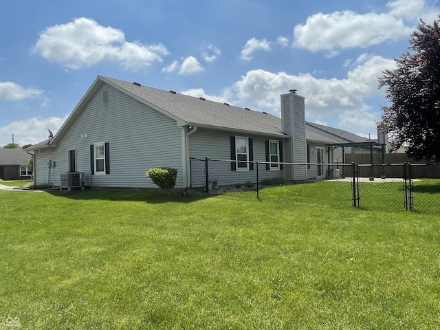 8234 Crosser Dr, Indianapolis, IN 46237 - back of house featuring fence, a chimney, central AC, and a lawn