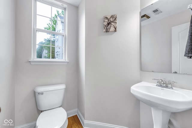 952 Junction Pl, Indianapolis, IN 46220 - half bathroom with toilet, baseboards, a sink, and wood finished floors