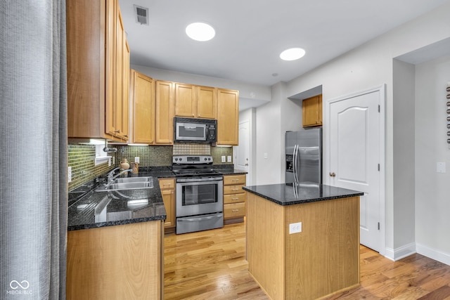 952 Junction Pl, Indianapolis, IN 46220 - kitchen with appliances with stainless steel finishes, a sink, a center island, backsplash, and light wood finished floors