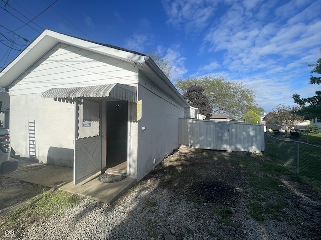 view of home's exterior featuring concrete block siding and fence