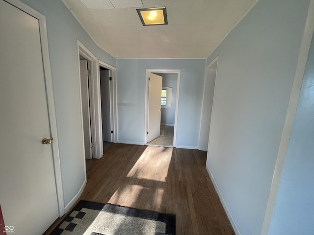 hallway with wood finished floors and baseboards