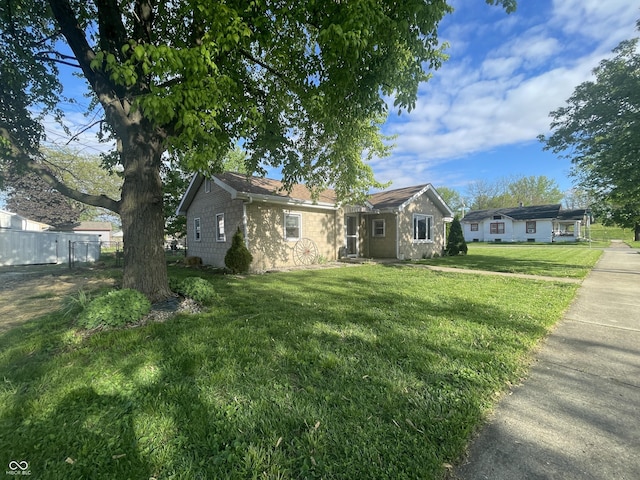 view of front of house with a front lawn and fence