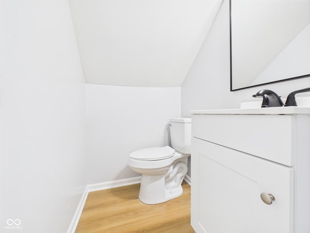 225 S Carthage Rd, Charlottesville, IN 46117 - half bathroom featuring lofted ceiling, wood finished floors, toilet, vanity, and baseboards