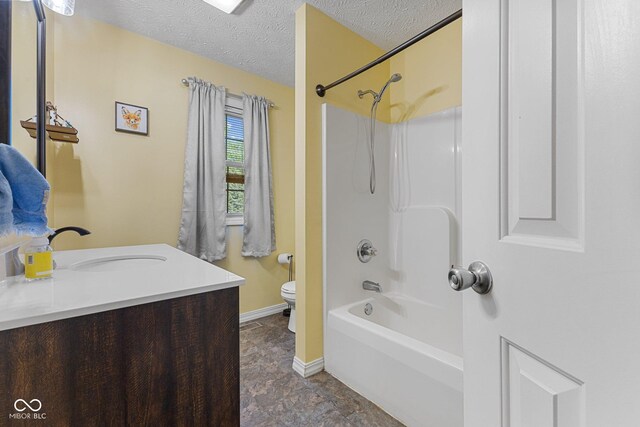 bathroom featuring toilet, a textured ceiling, baseboards, vanity, and tub / shower combination