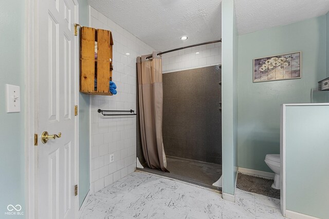 bathroom with a shower stall, a textured ceiling, toilet, and recessed lighting