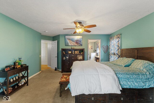 carpeted bedroom with baseboards, a textured ceiling, a ceiling fan, and connected bathroom