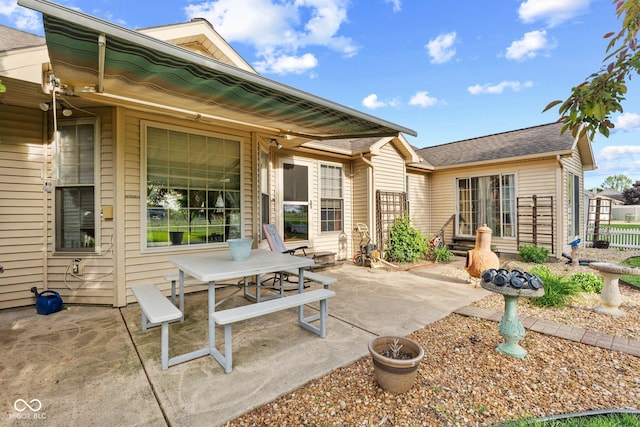 back of house with a patio and a shingled roof