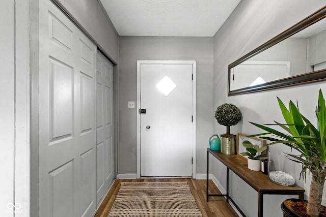 entryway with wood finished floors and baseboards