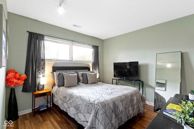 bedroom with wood finished floors and baseboards