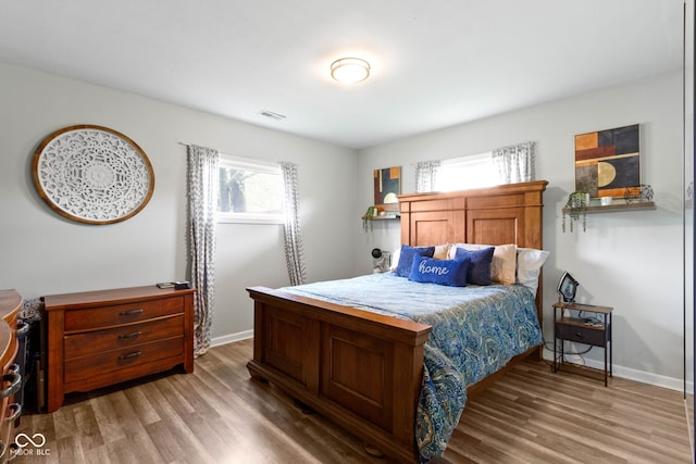 bedroom with light wood-type flooring and baseboards