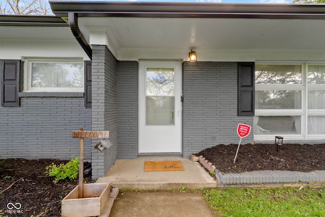 view of exterior entry with brick siding