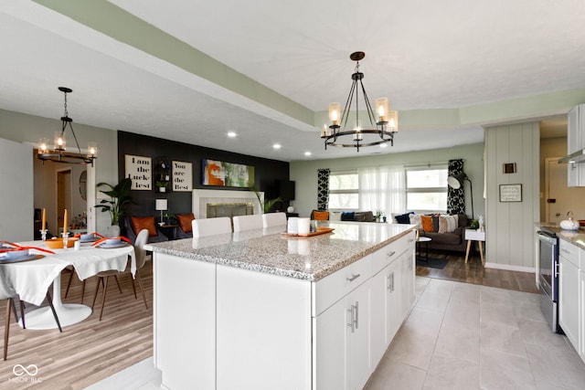 kitchen featuring a chandelier, open floor plan, stainless steel range with electric stovetop, and recessed lighting