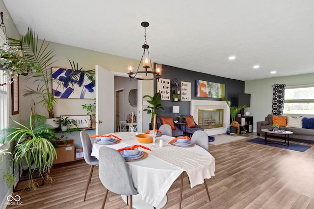 dining space with a chandelier, wood finished floors, and recessed lighting