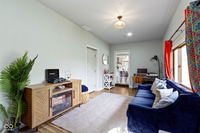 living area with a desk, wood finished floors, and baseboards