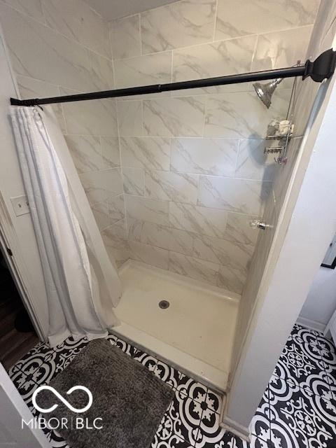 full bath featuring a shower stall and tile patterned flooring