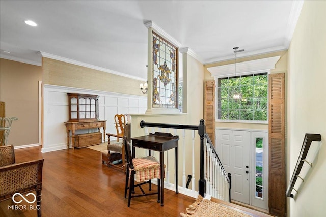 entryway with wood finished floors, crown molding, a chandelier, and baseboards
