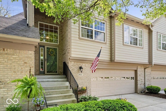 view of front of house with brick siding, a garage, and concrete driveway