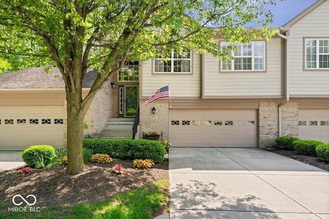 view of front of home with brick siding, driveway, and a garage
