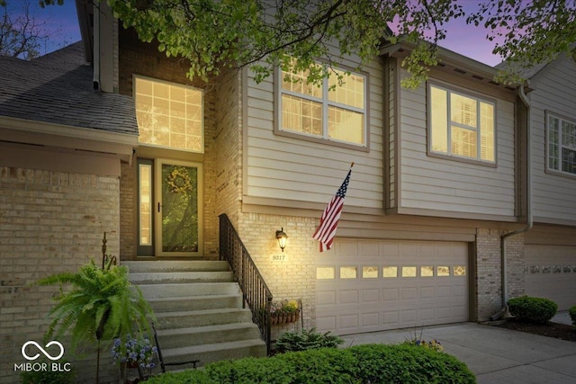 view of front of home featuring brick siding, an attached garage, and concrete driveway