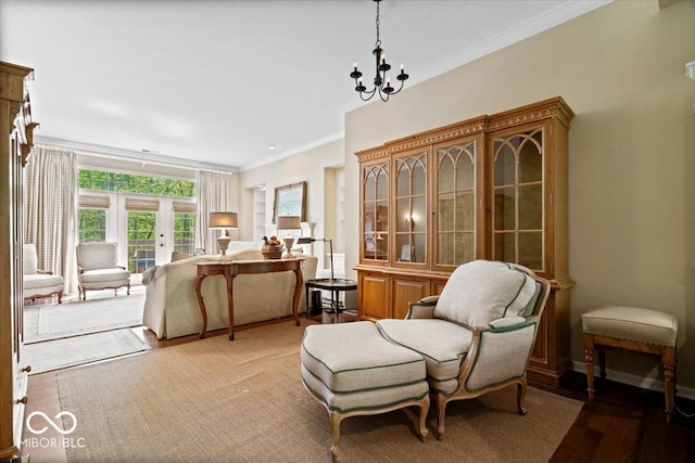 sitting room featuring crown molding, light wood-style flooring, and a chandelier
