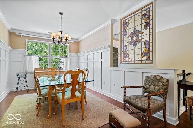 dining room featuring a decorative wall, ornamental molding, a chandelier, dark wood-style flooring, and a wainscoted wall