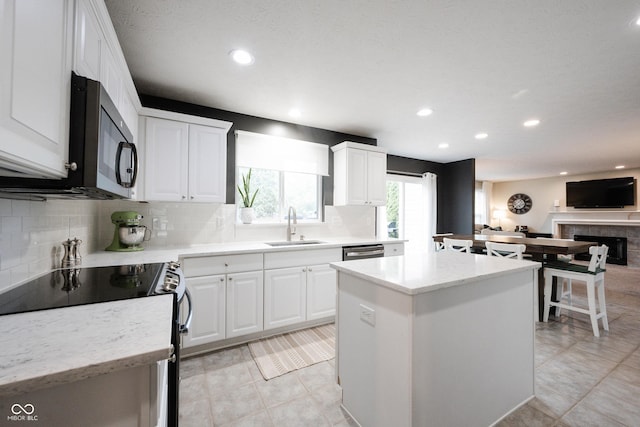 14030 Avalon E Dr, Fishers, IN 46037 - kitchen with a sink, electric range oven, a kitchen island, stainless steel dishwasher, and recessed lighting