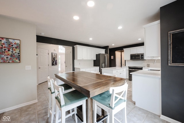 14030 Avalon E Dr, Fishers, IN 46037 - kitchen featuring appliances with stainless steel finishes, a kitchen island, light countertops, white cabinets, and recessed lighting