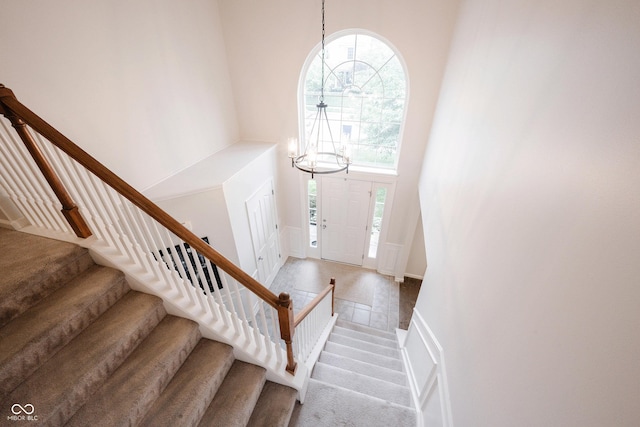 14030 Avalon E Dr, Fishers, IN 46037 - entryway with a high ceiling, a chandelier, stairway, baseboards, and carpet