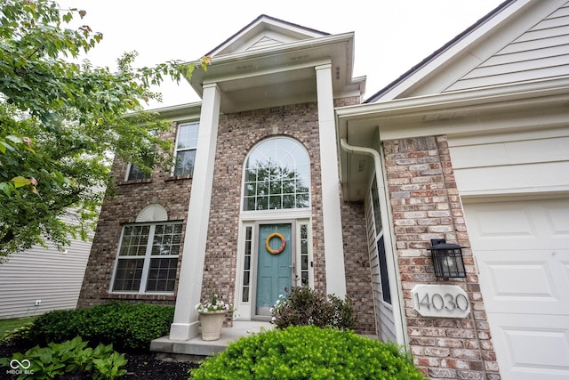 14030 Avalon E Dr, Fishers, IN 46037 - view of exterior entry featuring an attached garage and brick siding