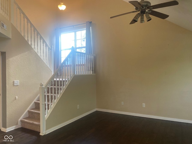 unfurnished living room with a ceiling fan, a high ceiling, and wood finished floors