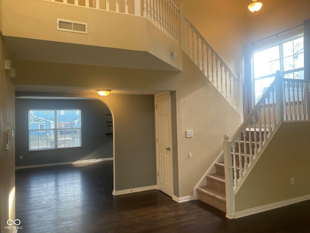 stairs featuring a wealth of natural light, baseboards, visible vents, and wood finished floors